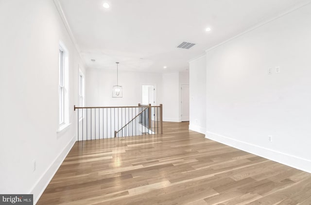 empty room with wood-type flooring and ornamental molding