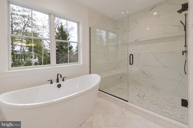 bathroom with a healthy amount of sunlight and separate shower and tub