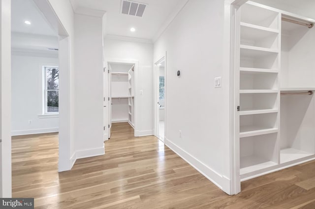 hallway featuring light hardwood / wood-style flooring and ornamental molding