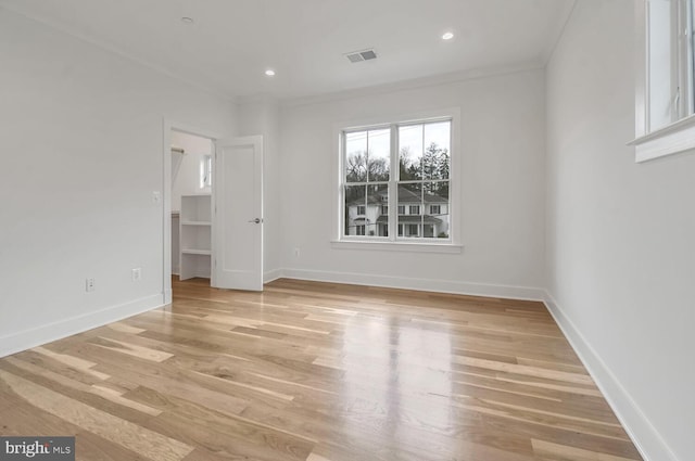 unfurnished room featuring ornamental molding and light hardwood / wood-style flooring