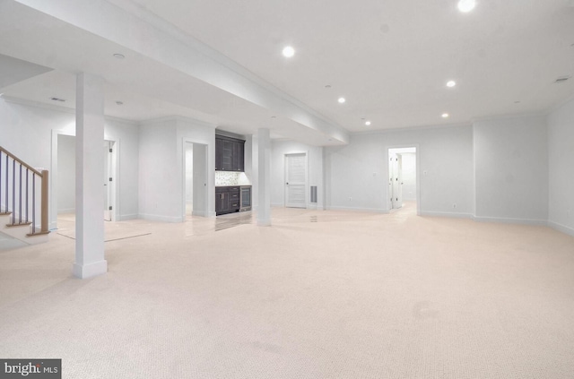 basement with ornamental molding and light carpet