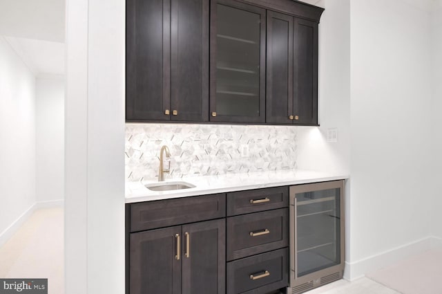 bar featuring sink, wine cooler, and dark brown cabinetry