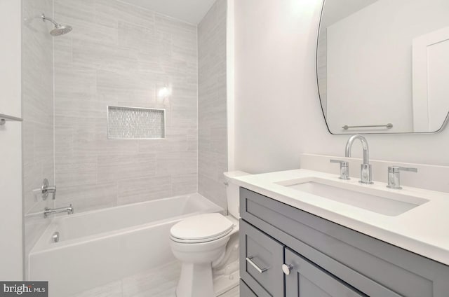 full bathroom featuring tiled shower / bath, vanity, and toilet