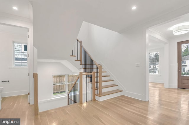 entrance foyer featuring crown molding and light wood-type flooring