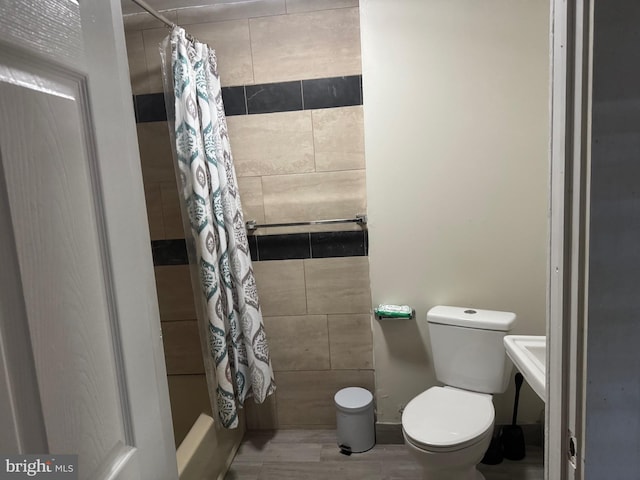 bathroom with shower / bath combination with curtain, toilet, and hardwood / wood-style flooring