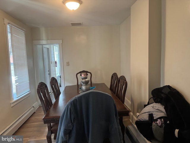 dining room featuring a baseboard radiator and light hardwood / wood-style floors