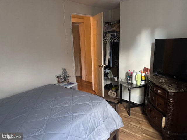 bedroom with light hardwood / wood-style floors and a closet