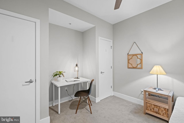 carpeted office space featuring ceiling fan