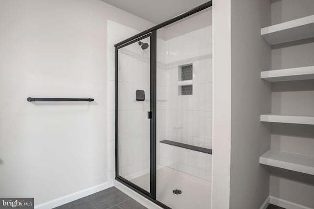 bathroom featuring baseboards, a stall shower, and tile patterned flooring