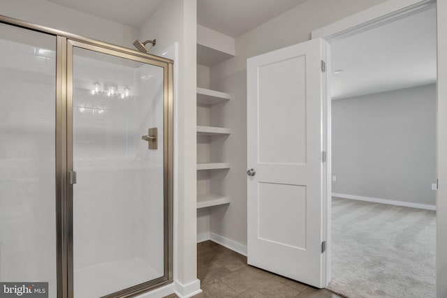 full bath with built in shelves, baseboards, and a stall shower