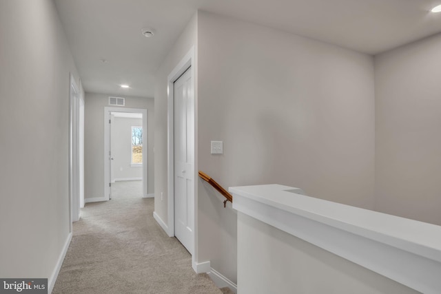 hall featuring an upstairs landing, recessed lighting, light colored carpet, and baseboards