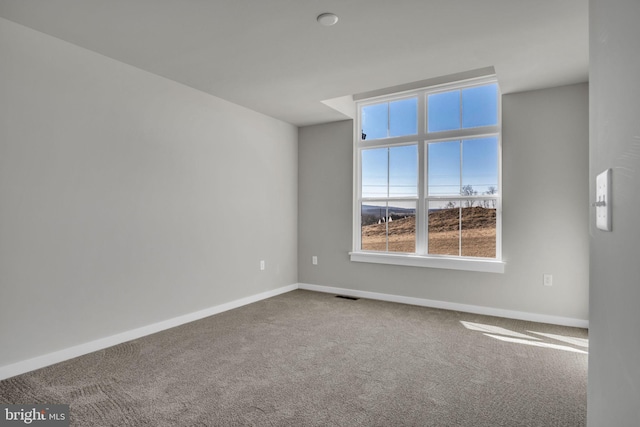 carpeted empty room featuring visible vents and baseboards