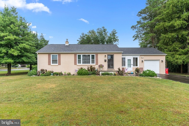 ranch-style home featuring a garage and a front lawn