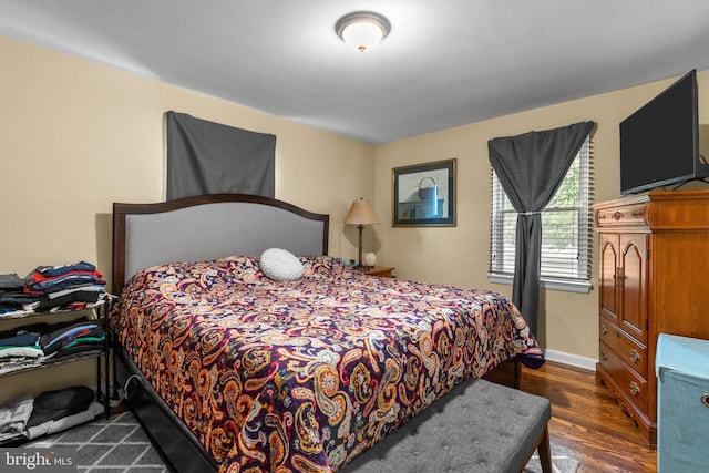 bedroom with dark hardwood / wood-style flooring