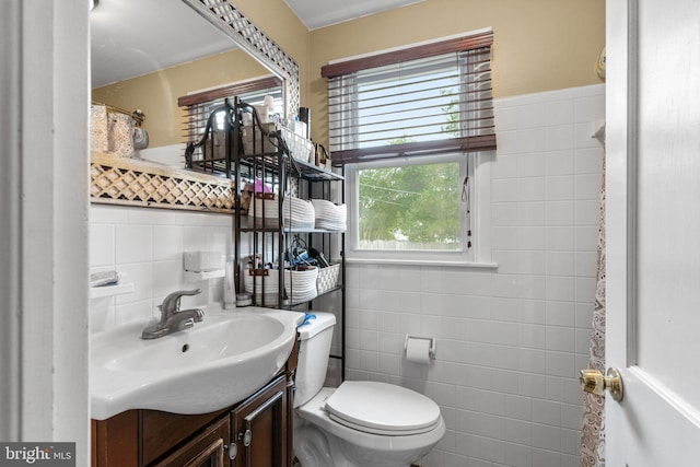 bathroom featuring vanity, toilet, and tile walls