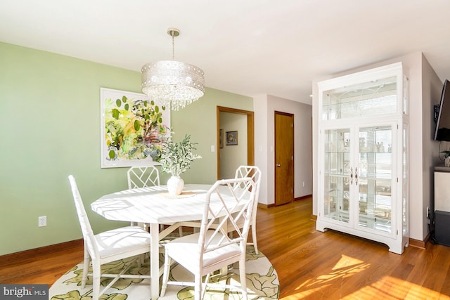 dining area featuring hardwood / wood-style flooring and a chandelier