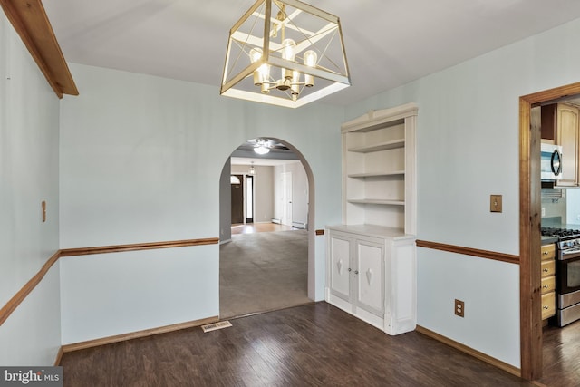 unfurnished dining area with an inviting chandelier and dark hardwood / wood-style floors