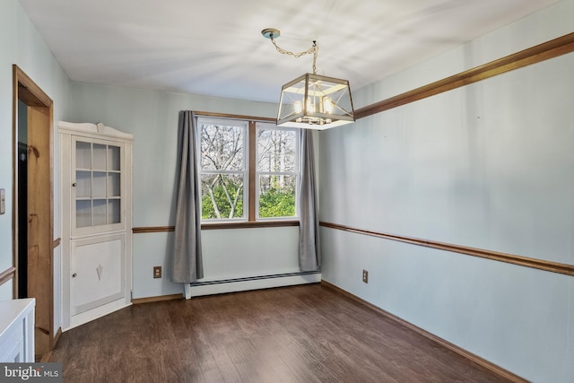 spare room with a baseboard heating unit, a chandelier, and dark hardwood / wood-style floors