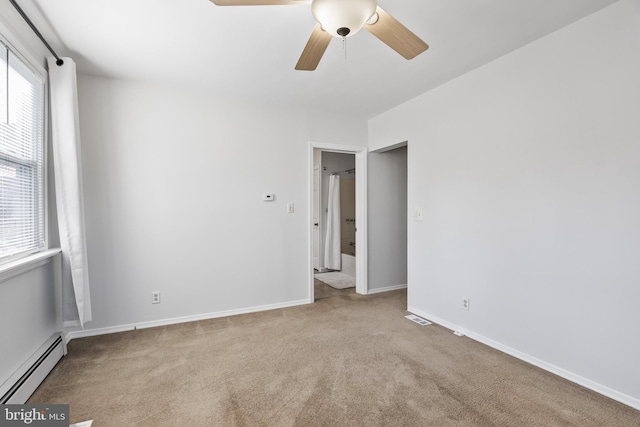 carpeted spare room with a healthy amount of sunlight, a baseboard heating unit, and ceiling fan