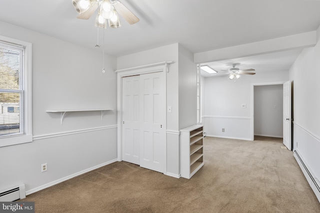 carpeted spare room featuring baseboard heating and ceiling fan