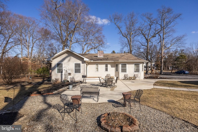 rear view of property featuring a patio area and a fire pit