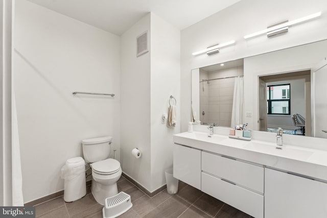 bathroom featuring vanity, curtained shower, tile patterned floors, and toilet