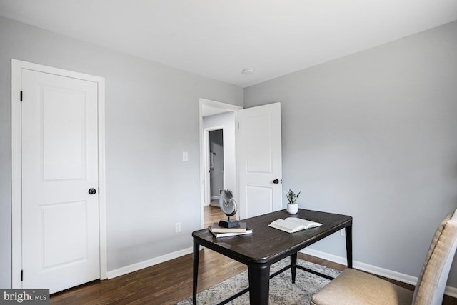 home office with dark hardwood / wood-style floors