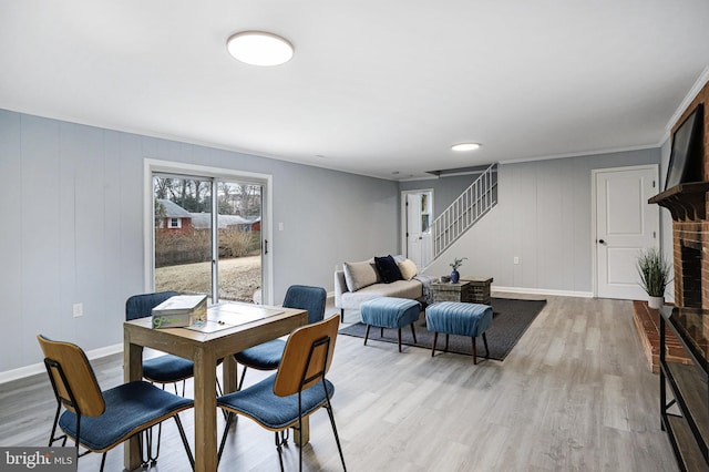 dining area featuring a brick fireplace and light hardwood / wood-style flooring