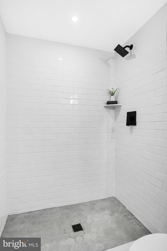 bathroom featuring a tile shower and toilet