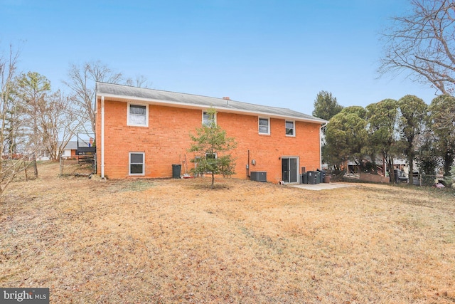 back of property with a yard and central AC