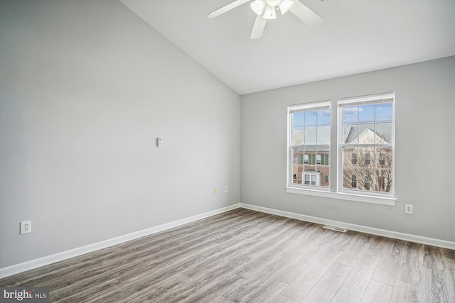 empty room featuring ceiling fan, lofted ceiling, and light wood-type flooring