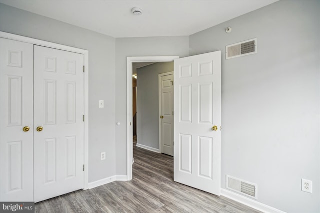 unfurnished bedroom featuring hardwood / wood-style flooring and a closet