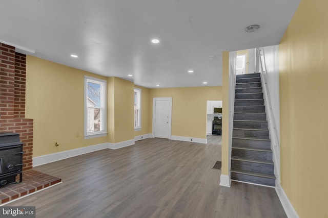 unfurnished living room with hardwood / wood-style floors and a wood stove