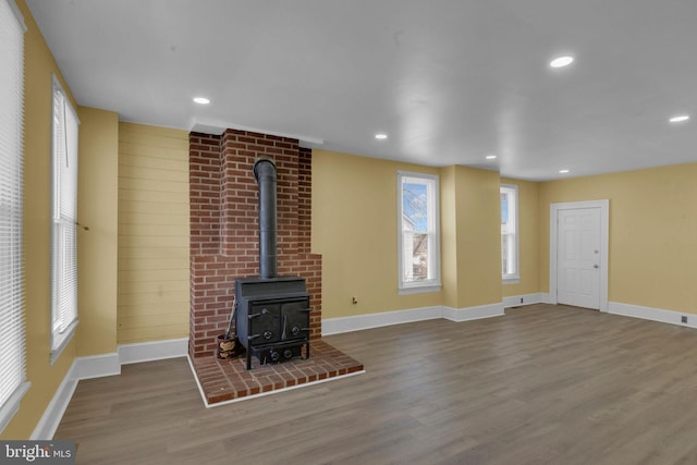 unfurnished living room featuring hardwood / wood-style flooring and a wood stove