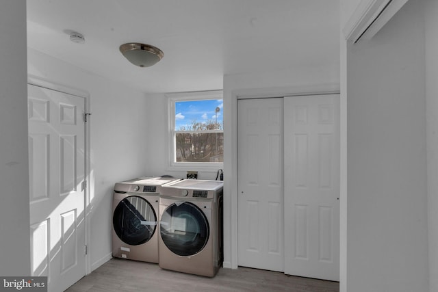 clothes washing area with light wood-type flooring and independent washer and dryer