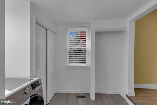 laundry area with washer / clothes dryer and light wood-type flooring