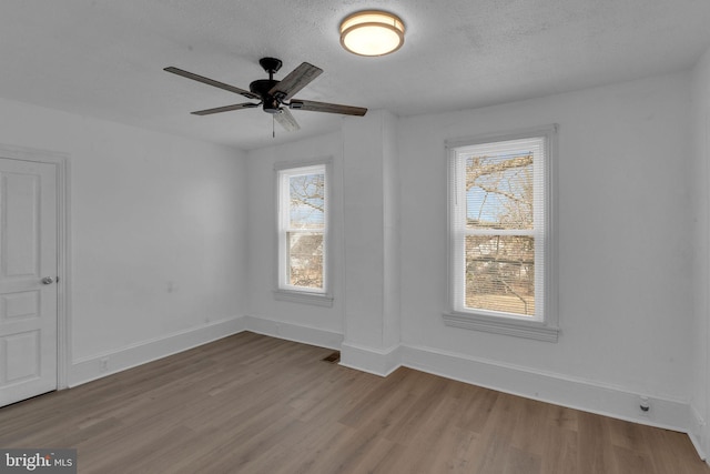 spare room with ceiling fan, light hardwood / wood-style floors, and a textured ceiling