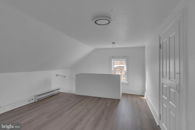 additional living space featuring hardwood / wood-style flooring, a baseboard radiator, and lofted ceiling