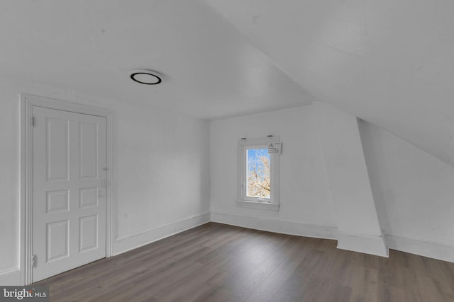 additional living space featuring lofted ceiling and dark wood-type flooring