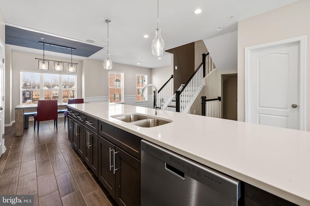 kitchen with pendant lighting, sink, dark brown cabinets, and stainless steel dishwasher