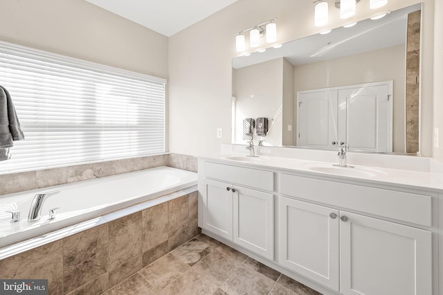 bathroom with vanity and tiled bath