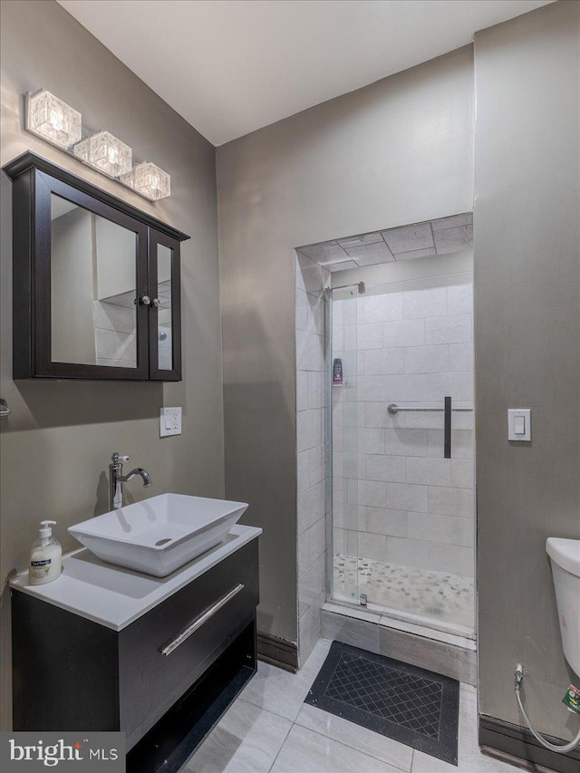 bathroom featuring vanity, toilet, tile patterned floors, and walk in shower