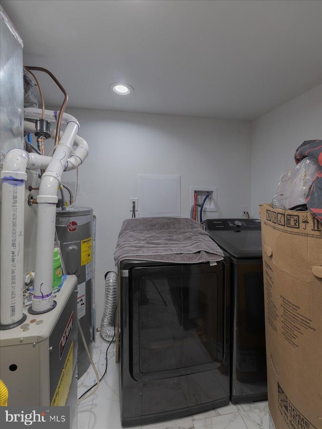 laundry area with water heater and washer and dryer