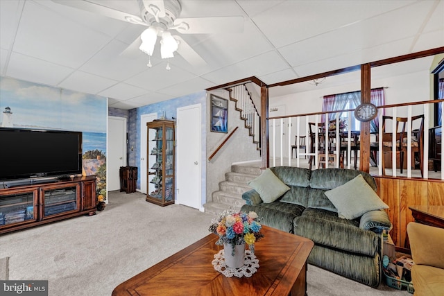 living room with a drop ceiling, ceiling fan, and carpet flooring