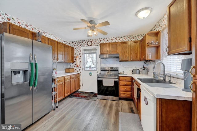 kitchen featuring tasteful backsplash, sink, ceiling fan, light hardwood / wood-style floors, and stainless steel appliances