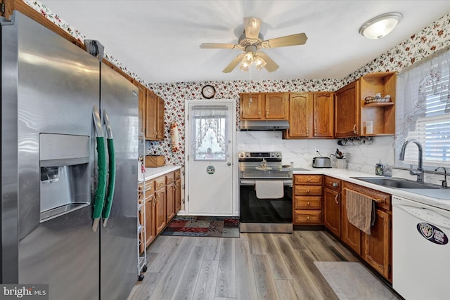 kitchen featuring a healthy amount of sunlight, appliances with stainless steel finishes, sink, and light hardwood / wood-style floors