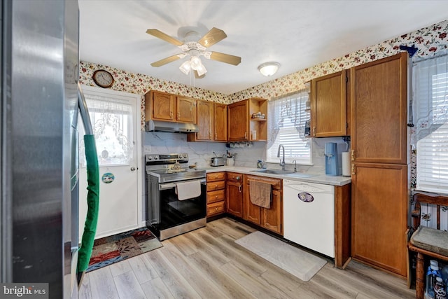 kitchen featuring sink, ceiling fan, appliances with stainless steel finishes, tasteful backsplash, and light hardwood / wood-style floors