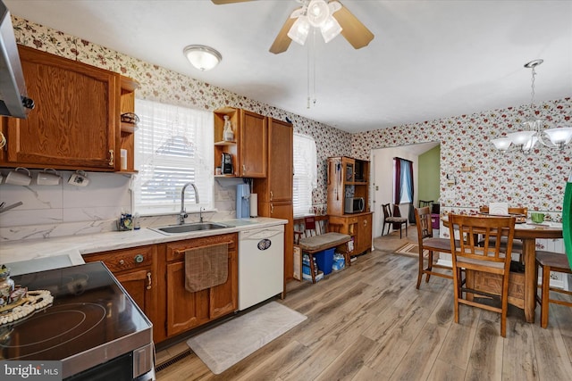 kitchen with stainless steel electric stove, pendant lighting, dishwasher, sink, and light hardwood / wood-style flooring