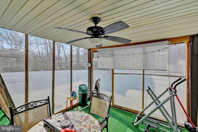 unfurnished sunroom featuring ceiling fan