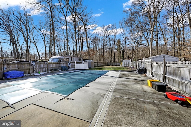 view of pool with a patio area and a storage shed